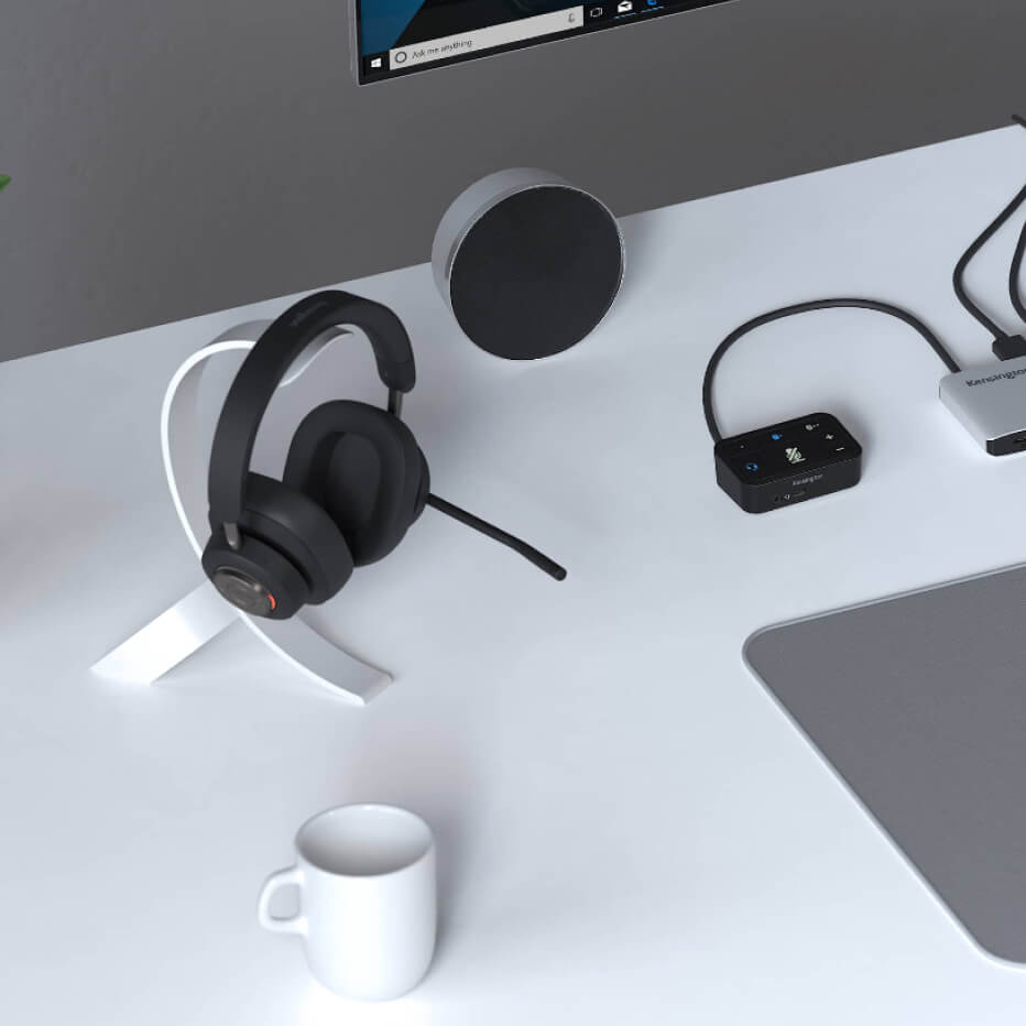 Primo piano di cuffie over-ear Bluetooth H3000 e commutatore audio universale 3 in 1 Pro Kensington come parte della configurazione di una scrivania professionale