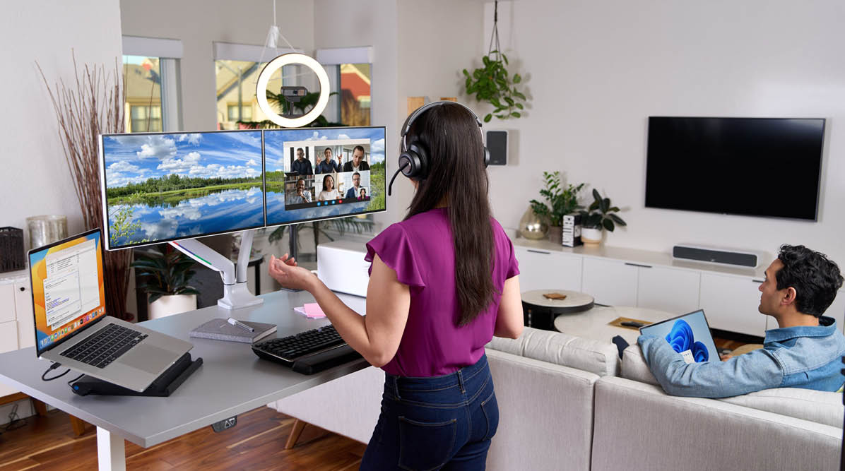 Woman working at a standing desk in a virtual meeting using Kensington video conference accessories