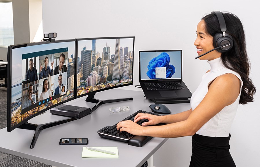 A woman in a video call using a docking station to connect her laptop to multiple devices.
