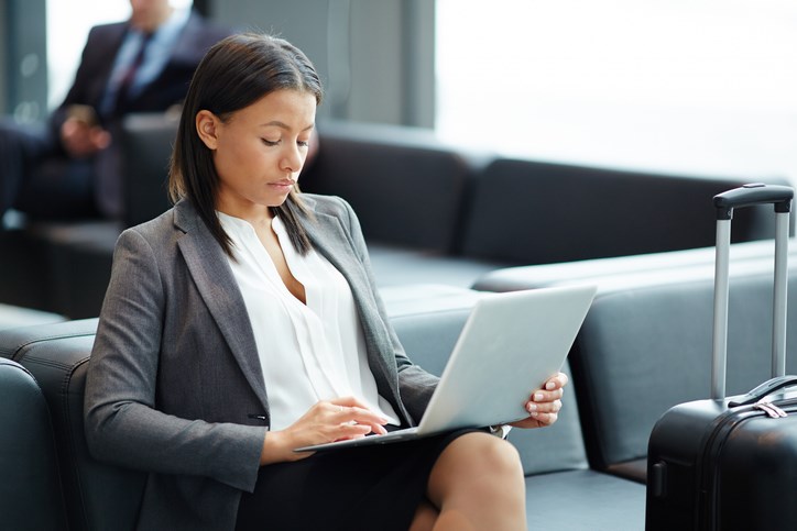 A business professional working on their laptop at the airport departure lounge.