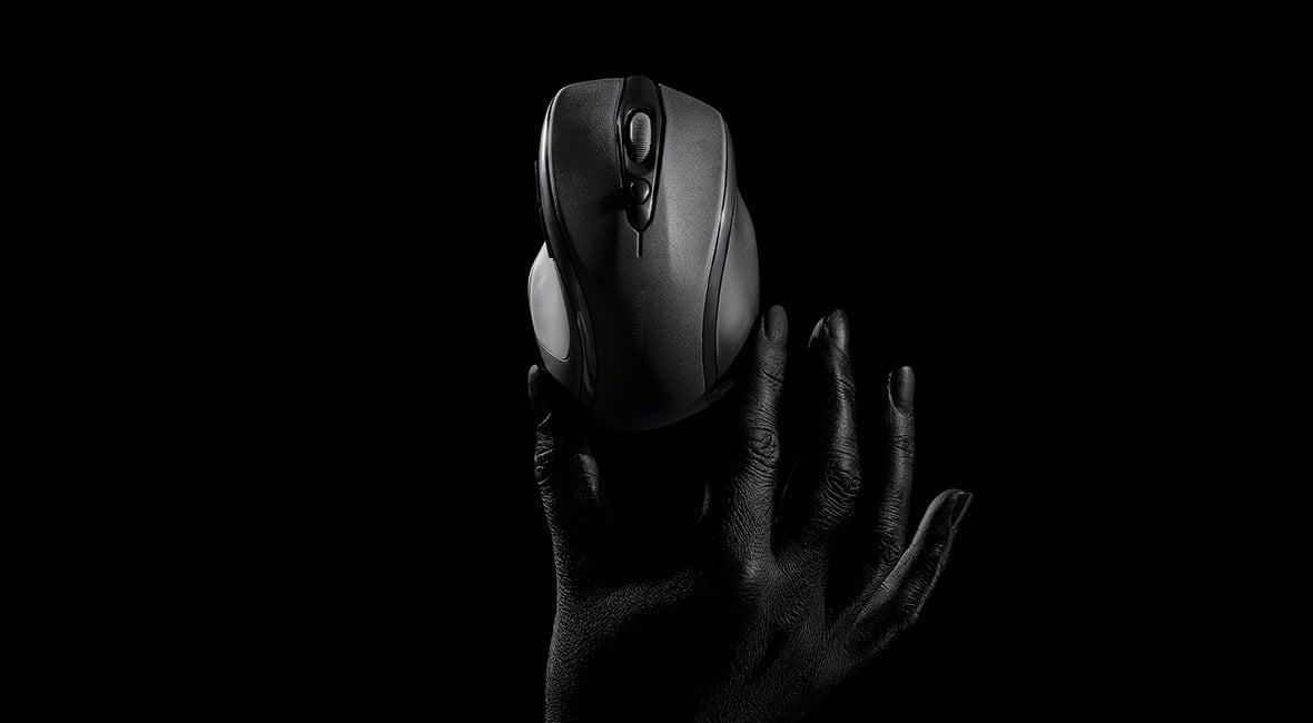 A black MY310 EQ Wireless Mid-Size Mouse held in a human hand against a dark background. 