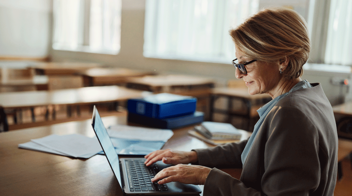 Woman working from the classroom using her laptop.