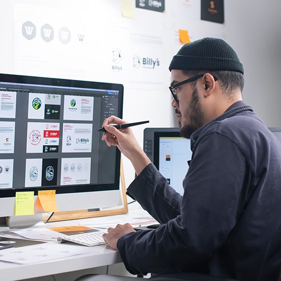 Man at desk uses a monitor with a Kensington High Clarity Privacy Screen Filter.