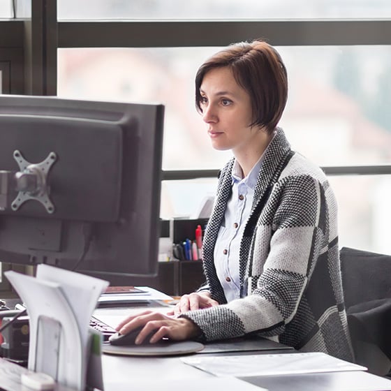 Woman uses desktop with Kensington Direct Attach Privacy Screen Filter.