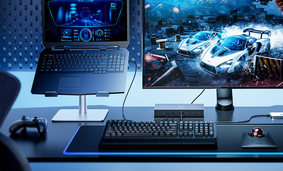 Professional gaming setup with blue accents featuring a Kensington SD5000T5 EQ Thunderbolt Docking Station, 4K monitor, Bluetooth Over-Ear Headset, and mechanical keyboard.