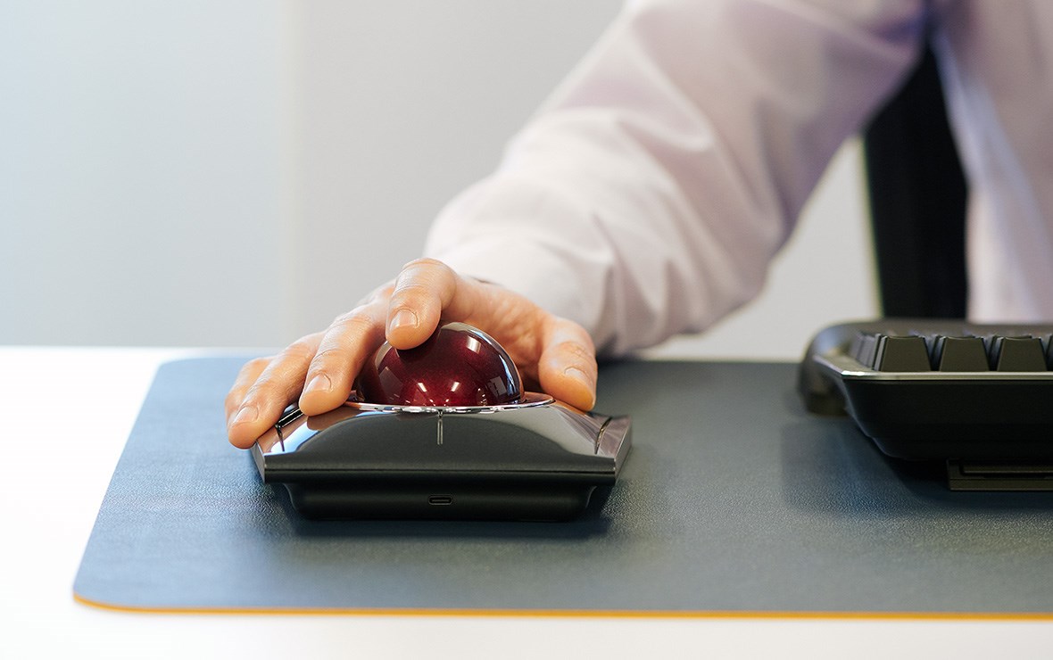 Un hombre trabajando en un proyecto con el trackball Expert, que ofrece un control de precisión.